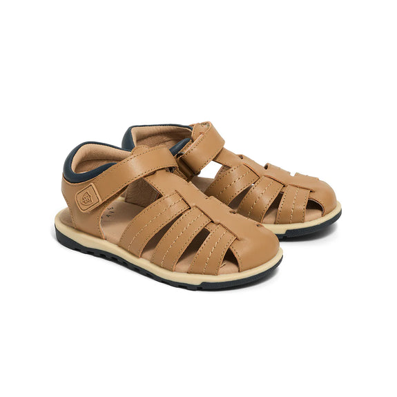 Pair of tan sandals with black soles on a white background
