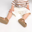 Child wearing brown shoes on a white background