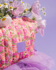 Floral-patterned bag with a purple tag and tulle against a light purple background