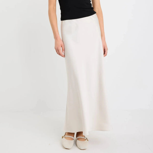 Woman wearing a black sleeveless top and white pants on a white background