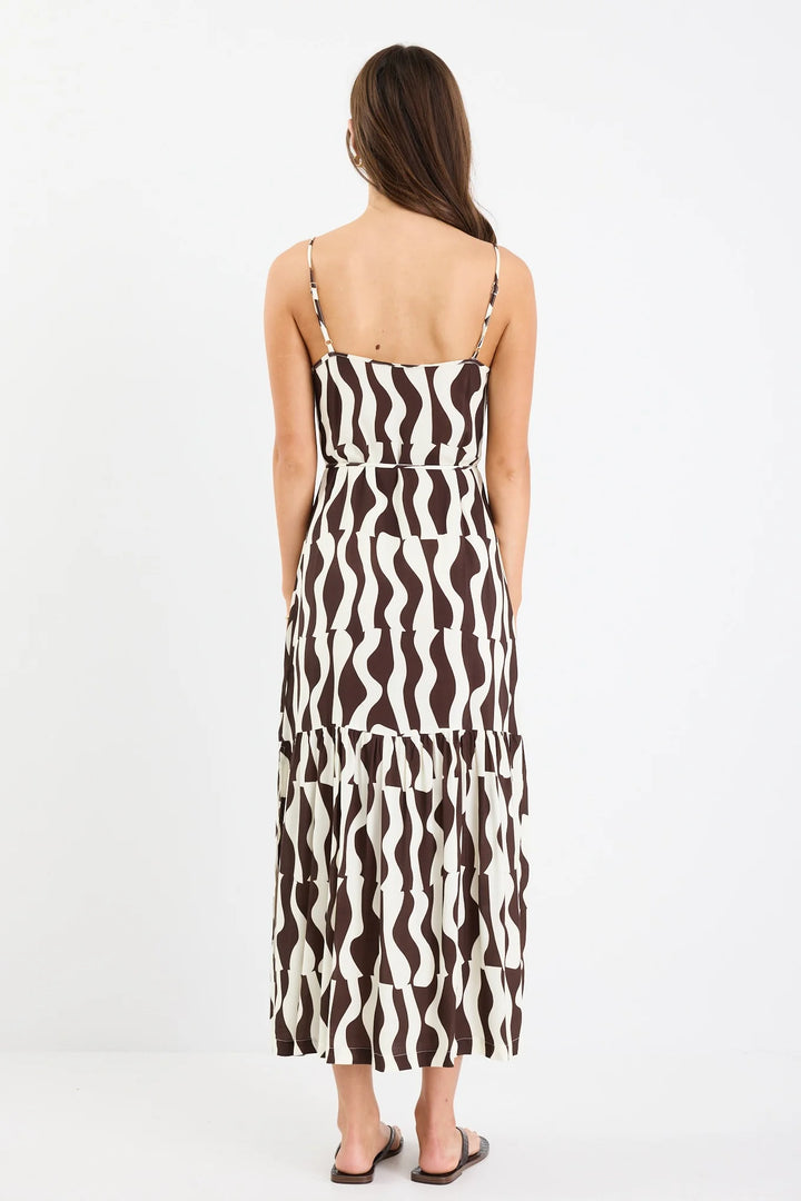 Woman wearing a black and white patterned dress on a white background