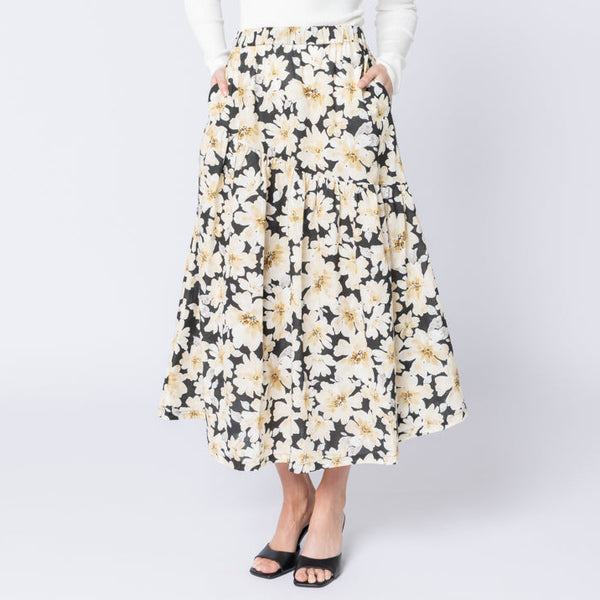 Woman wearing a floral skirt and white top on a white background