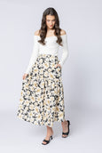 Woman wearing a white off-shoulder top and floral skirt on a white background