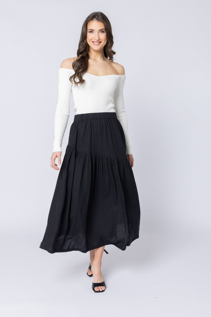 Woman wearing a white top and black skirt on a white background