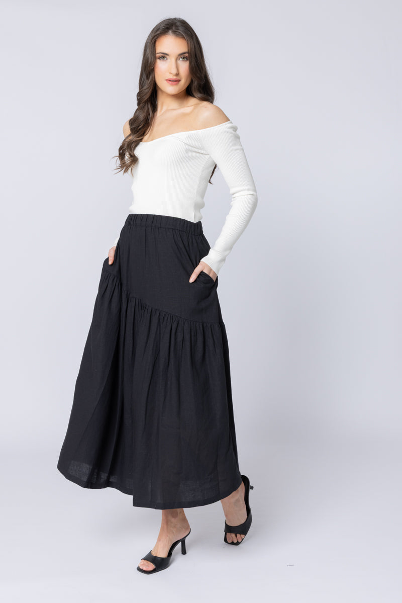 Woman wearing a black skirt and white top on a white background