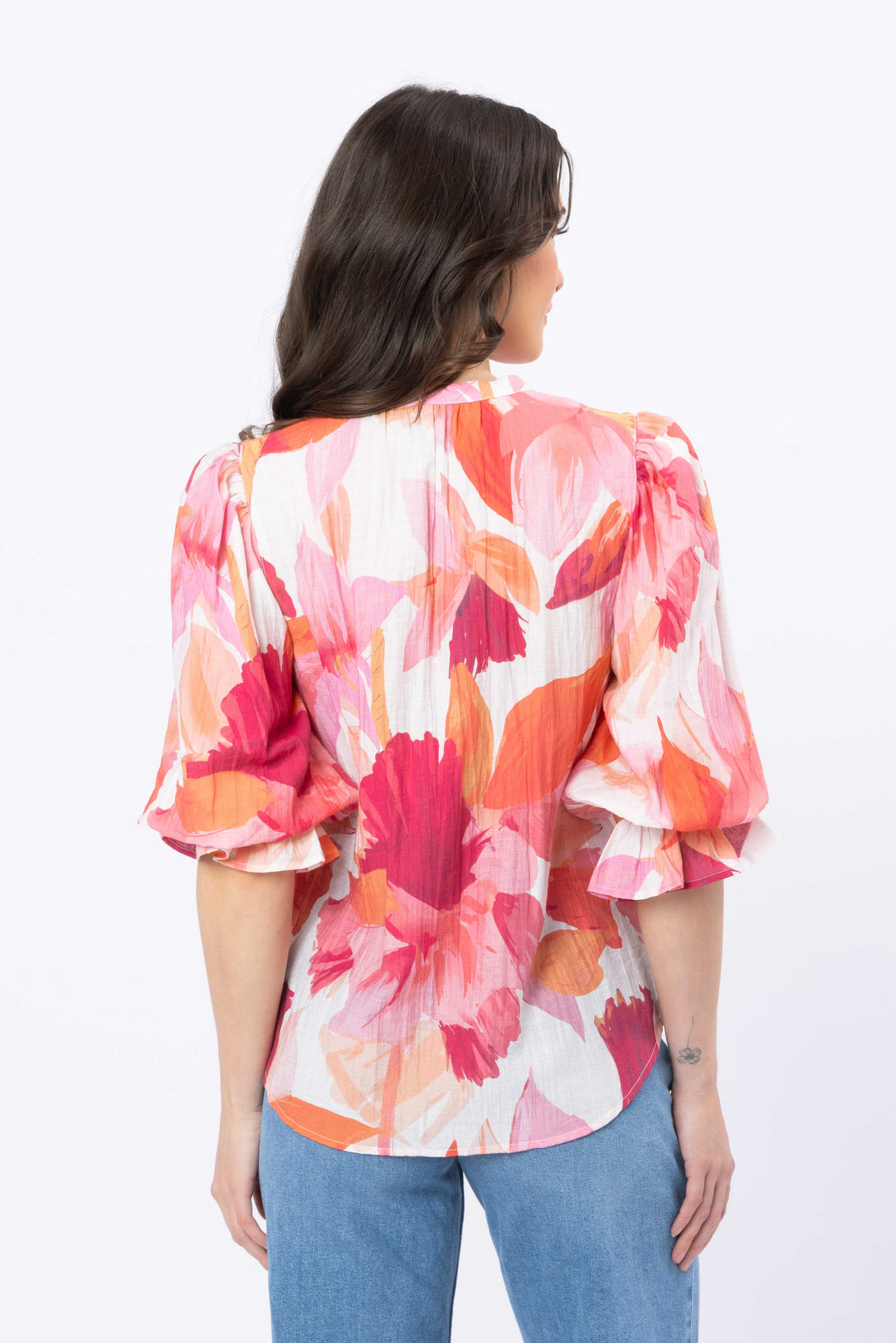 Woman wearing a colorful floral blouse with a white background