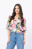 Woman wearing a floral blouse and blue jeans on a white background