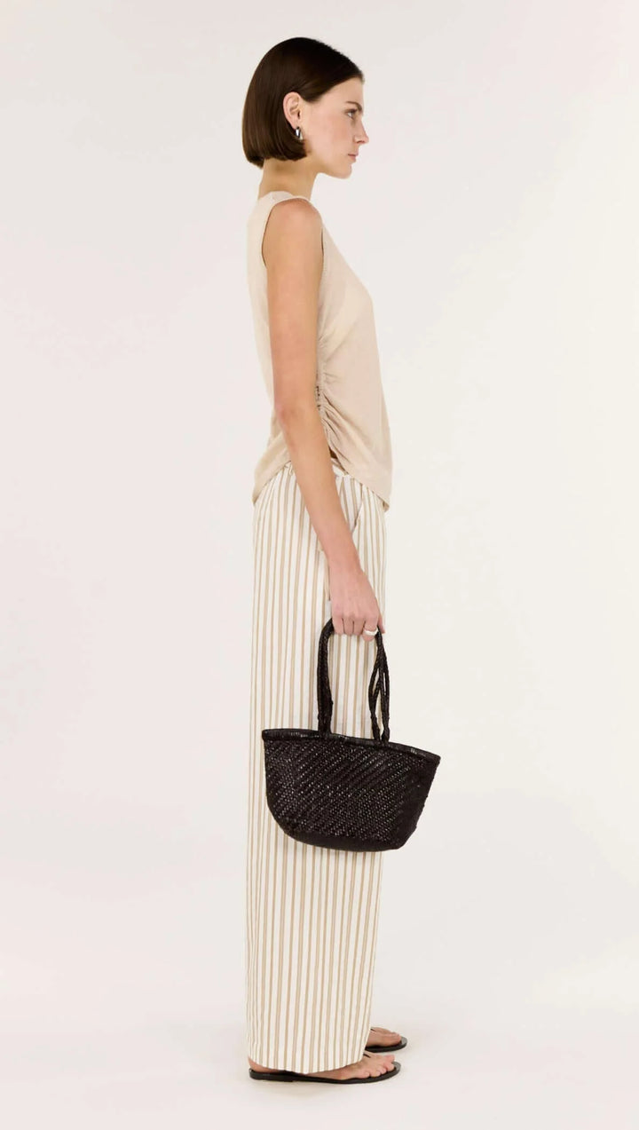 Woman holding a black handbag against a white background