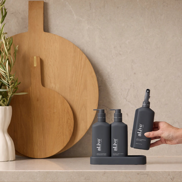 Bath products with 'alive' branding on a countertop with wooden cutting boards and a plant in the background.
