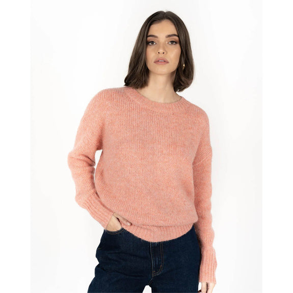 Woman wearing a pink sweater on a white background