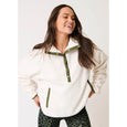 Woman wearing a cartel & willow white fleece Mattie pullover with green accents on a plain background