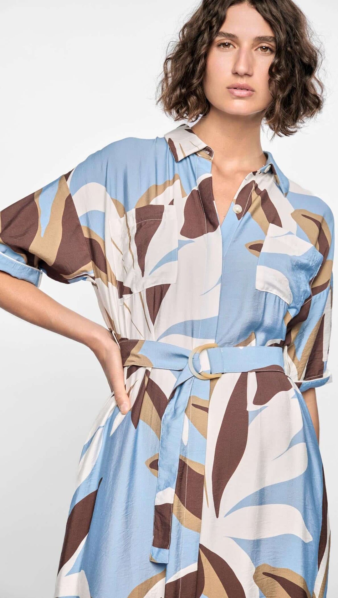 Woman wearing a patterned dress with a white background