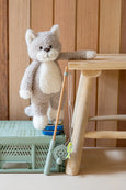 Stuffed animal toy on a wooden stool with a wooden wall background