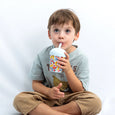 Child drinking from a colorful cup with a straw against a white background