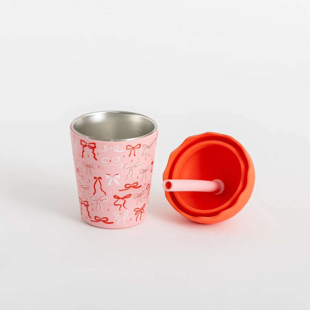 Pink stainless steel cup with red lid and straw on a white background