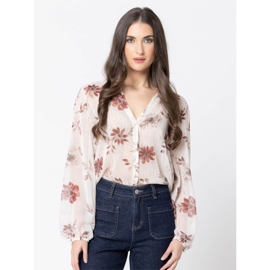 Woman wearing a floral blouse and jeans on a white background
