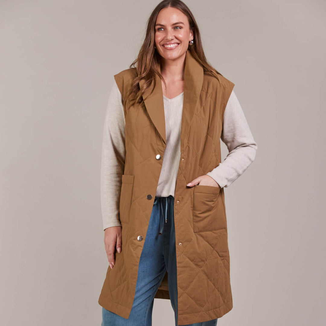 Enhance your outerwear collection with the Argo Long Line Vest. This stylish, quilted cotton vest is designed for comfort and warmth, featuring a lapel with a three-button press stud closure and a knee-length cut to keep the chill at bay. Available from www.thecollectivenz.com