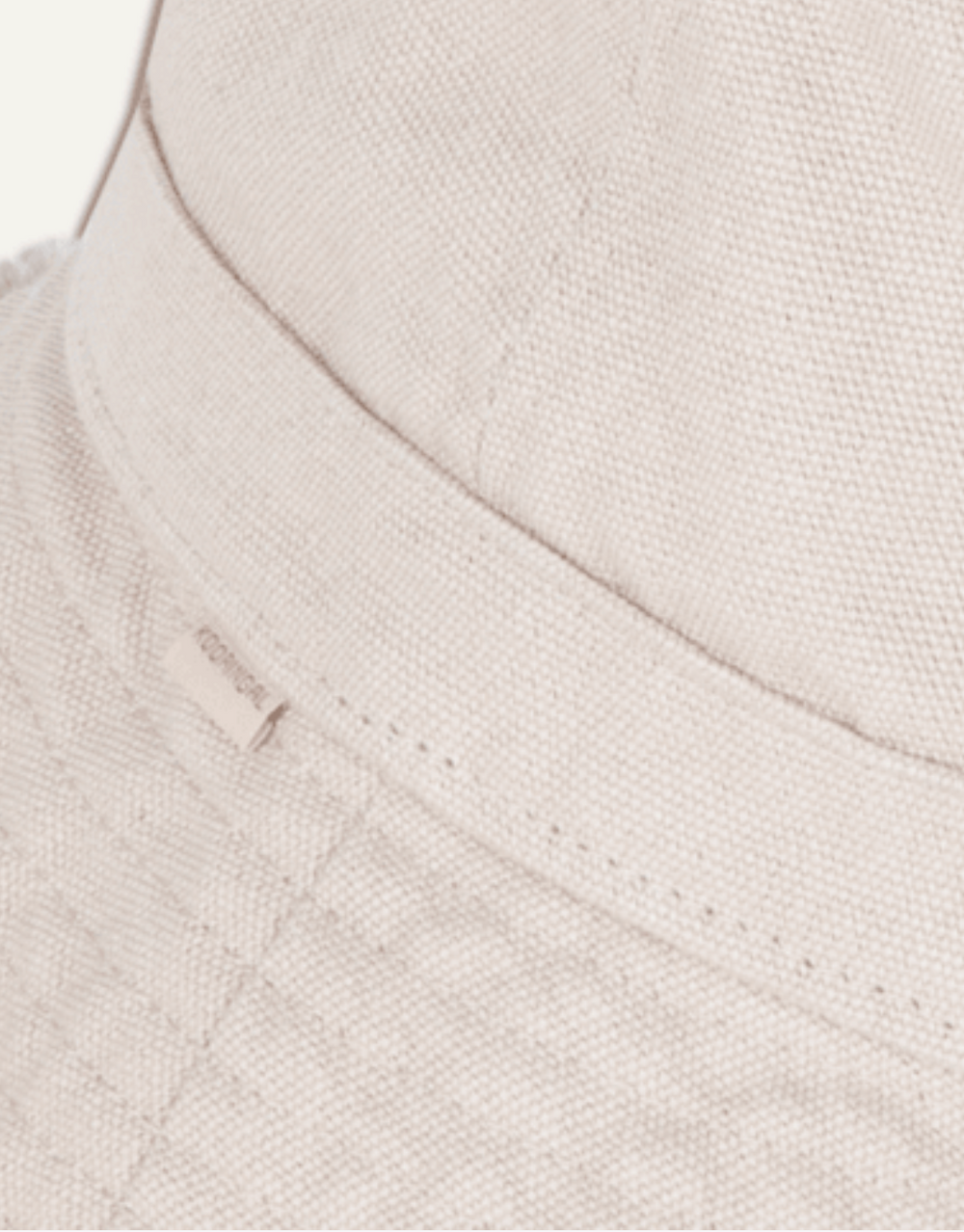 Close-up of a textured beige fabric with a brand label.