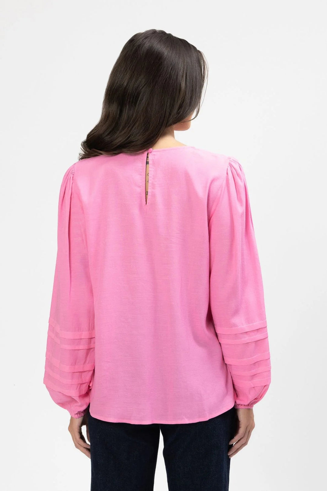 Person wearing a pink Milly blouse with long sleeves on a white background