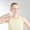 Woman wearing a yellow tank top against a plain background