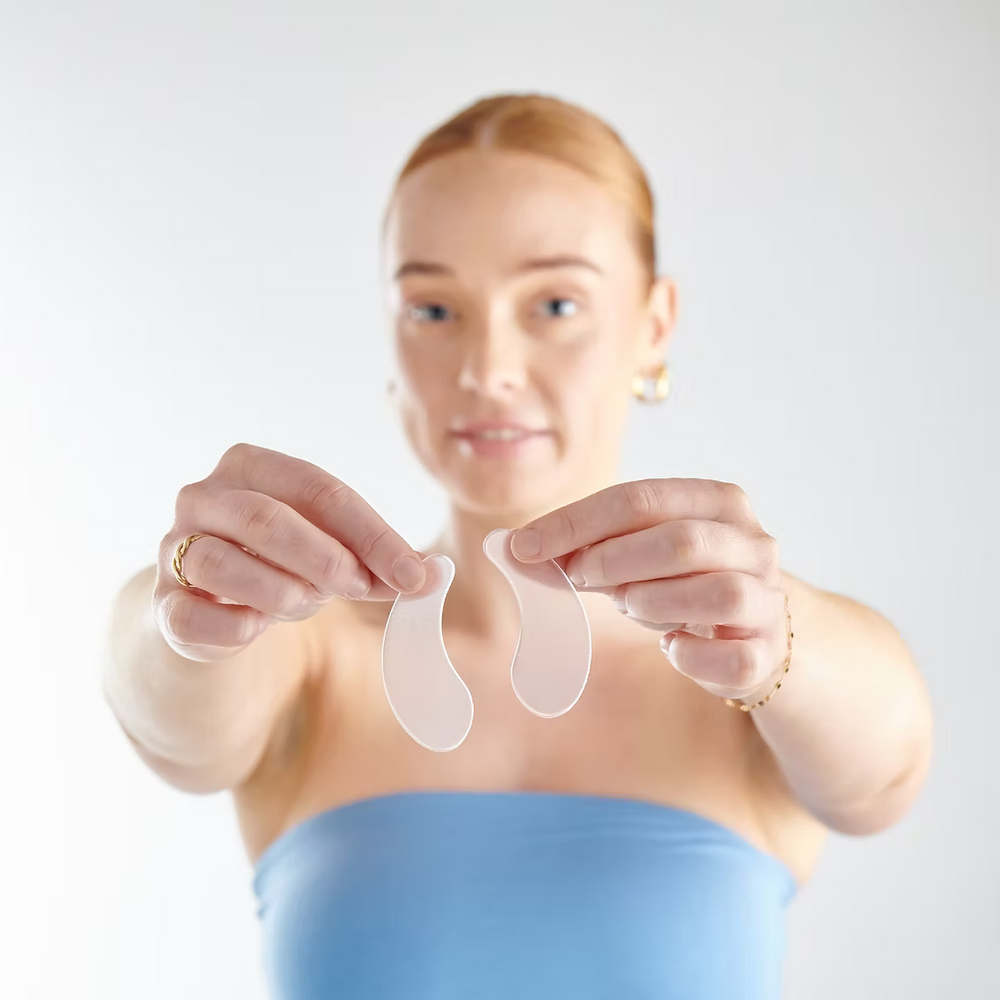 Woman holding two silicone gel pads against a white background