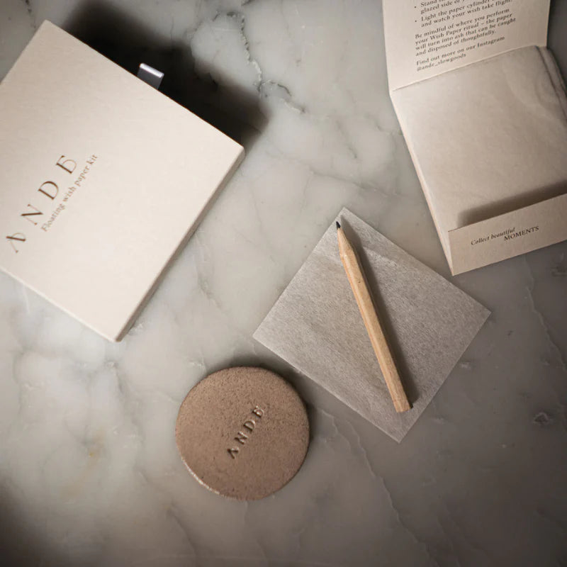 Pencil on a piece of paper with 'ANDE' branding on a marble surface