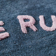 Pink letters spelling 'ERU' on a textured blue surface