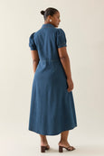 Woman wearing a blue isle of mine dress against a white background
