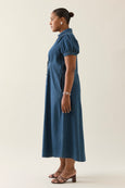 Woman wearing a blue isle of mine dress against a plain background