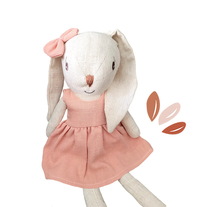 Stuffed bunny toy with a pink dress on a white background
