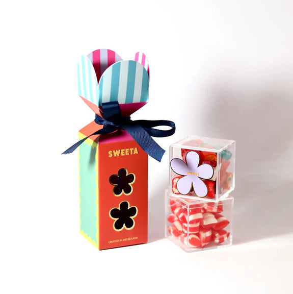 Colorful candy box with striped lollipops and a clear container of candies on a white background