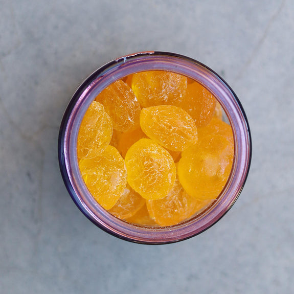 Jar of orange pickles on a gray surface