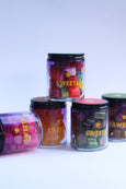 Clear jars with colorful candies labeled 'SWEET' on a white background