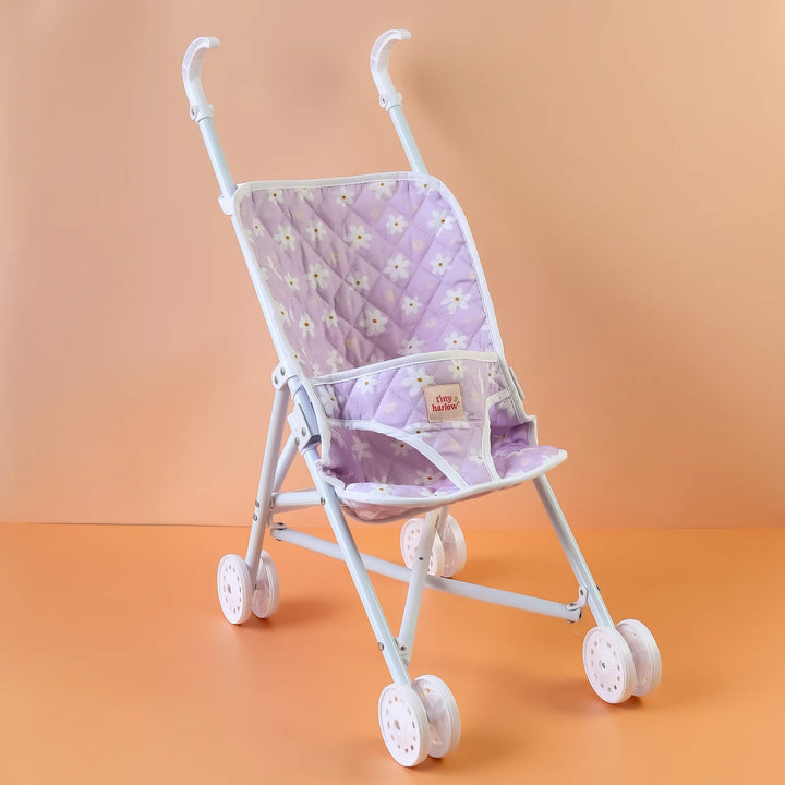 Tiny Harlow Purple floral-patterned dolls stroller against an orange gradient background